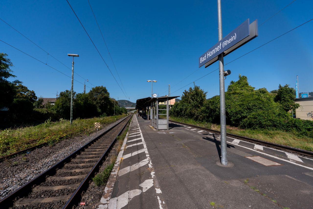Ein sonniger Bahnsteig, auf dem ein Schild mit dem Titel "Bad Honnef (Rhein)" steht.