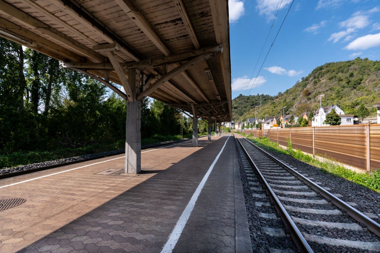 Bahnsteig des Bahnhof Brauchbach, umgeben von Grün und Felsen.