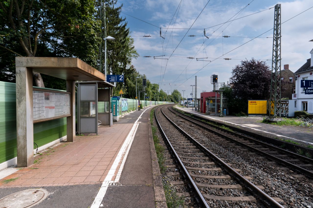 Bahnsteig des Bahnhof Erbach mit Gleisen, einem Unterstand und Schildern für die Bahnsteige 1 und 2.