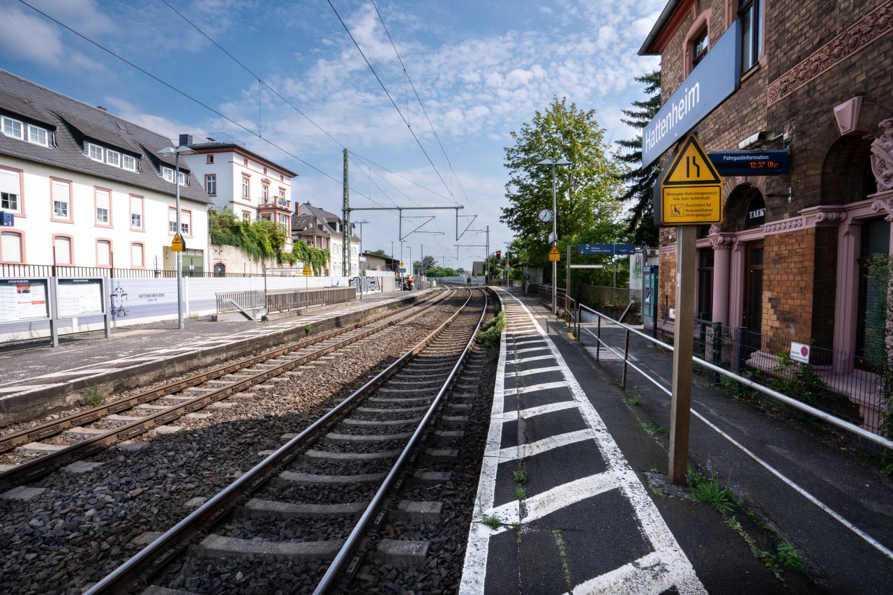 Bahnhofshäuschen Hattenheim mit zwei Gleisen und Bahnsteigen an einem sonnigen Tag.